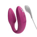 Magenta We-Vibe Sync couples vibrator with textured and smooth silicone arms, shown with white USB charging cable.