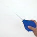Hand holding a blue 11 oz bulb douche with a translucent nozzle spraying water against a white background.
