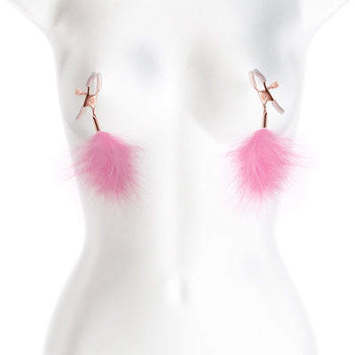 Rose gold adjustable nipple clamps with soft silicone tips and pink feather accents on a white mannequin torso.