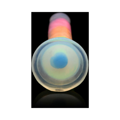 Close-up view of the suction cup base of a rainbow-colored silicone dildo glowing softly against a black background.