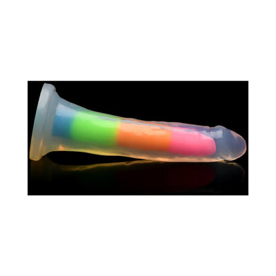 Rainbow-colored glow-in-the-dark silicone dildo with suction base on black reflective surface.