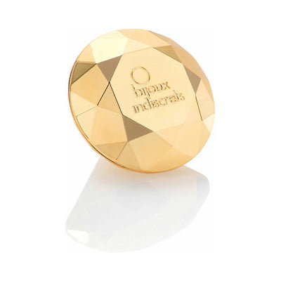 Gold faceted diamond-shaped clitoral vibrator with Bijoux Indiscrets logo on a white reflective surface.