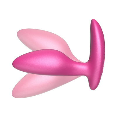 Pink silicone We-Vibe Ditto+ vibrating anal plug with ergonomic shape and tapered tip on white background.