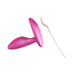 Pink silicone We-Vibe Ditto+ vibrating anal plug with remote control and USB charging cable on white background.