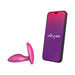 Pink silicone vibrating anal plug next to smartphone displaying We-Vibe app interface for remote control.