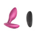 Pink silicone vibrating anal plug with ergonomic base and black remote control with buttons on white background