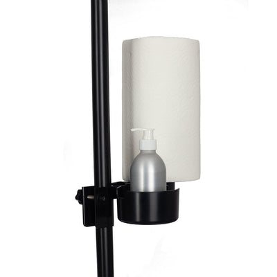 Black metal holder attached to vertical pole with a silver pump bottle and a roll of white paper towels.
