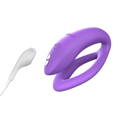 Purple We-Vibe Sync O couples vibrator with USB charging cable on a white background.