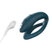 Dark teal flexible silicone We-Vibe Sync O couples vibrator with USB charging cable on white background.