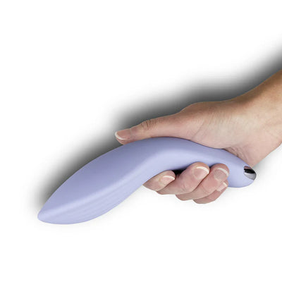 Hand holding a curved, ergonomic cornflower blue silicone couples massager with a smooth finish and metallic accent.