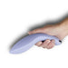 Hand holding a curved, ergonomic cornflower blue silicone couples massager with a smooth finish and metallic accent.