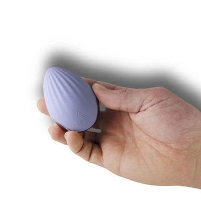 Hand holding a compact, cornflower blue, palm-held massager with textured silicone surface and discreet design.