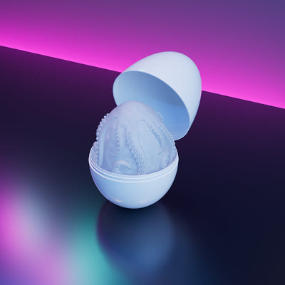 Lovense Kraken Egg male pleasure device in white with textured interior, displayed open on reflective surface with purple lighting.