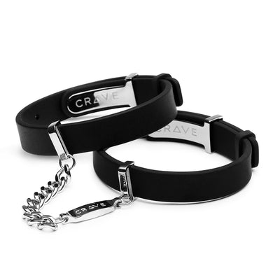 Black silicone Crave ID Cuffs with polished silver-tone stainless steel hardware and connecting chain detail.