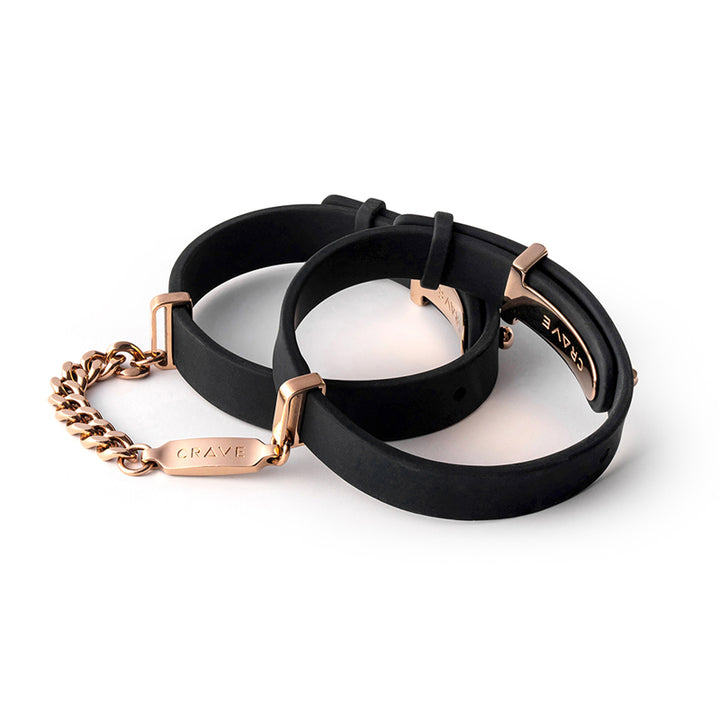 Black silicone ID cuffs with rose gold stainless steel hardware and chain detail on white background.