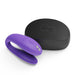 Purple We-Vibe Sync Go couples vibrator with black textured travel case on white background