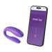 Purple We-Vibe Sync Go couples vibrator next to smartphone displaying its control app interface.