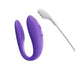Purple We-Vibe Sync Go couples vibrator with white magnetic charging cable on white background.