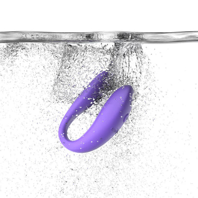 Purple We-Vibe Sync Go couples vibrator submerged in water with bubbles, highlighting its waterproof feature.