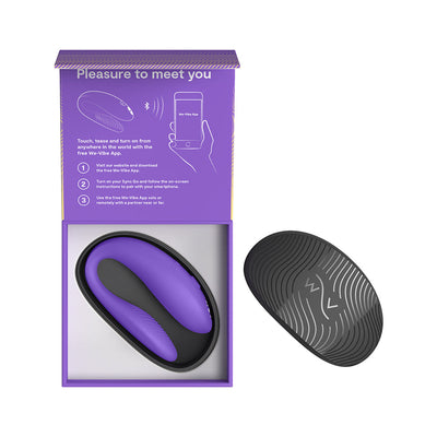 Purple and black We-Vibe Sync Go couples vibrator in open purple box with instructions and black textured travel case beside it.