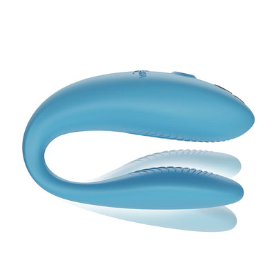 Blue ergonomic couples vibrator with flexible arms and textured inner surfaces for dual stimulation.