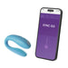 Blue We-Vibe Sync Go couples vibrator next to smartphone displaying its control app interface.