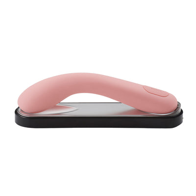 Elegant pink curved personal massager resting on a sleek black and silver charging base.