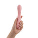 Hand holding a sleek, pink iroha mai TOKI personal massager with a smooth, ergonomic design.