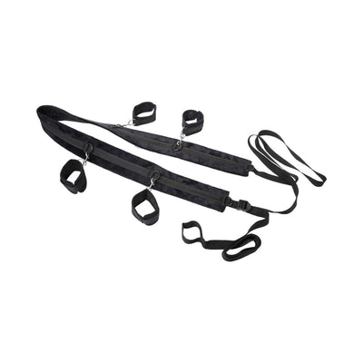 Black adjustable restraint system with padded straps and four attached cuffs for versatile positioning.