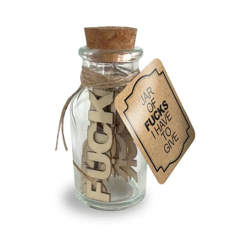 Small glass jar with cork lid containing wooden tokens and a tag labeled Jar of Fucks I Have to Give