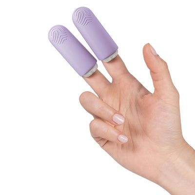 Hand wearing two lavender silicone fingertip massagers on index and middle fingers against white background.