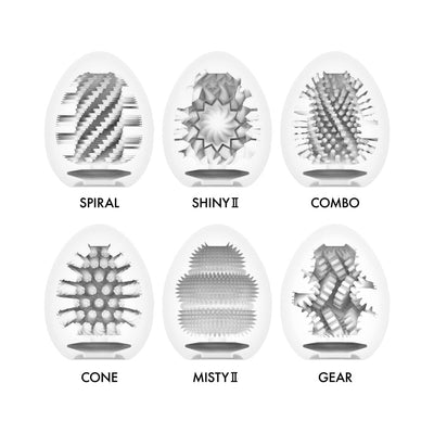 Cross-section views of six Tenga EGG Hard Boiled II textures: Spiral, Shiny II, Combo, Cone, Misty II, and Gear inside white egg-shaped sleeves.