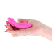 Hand holding a compact magenta silicone wearable panty vibrator with a smooth, curved design.