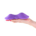 Hand holding the purple Techno Trap hands-free silicone grinding pad with textured surface.