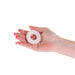 Hand holding a medium white Firefly Bubble Ring made of soft silicone against a white background.