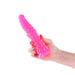 Hand holding a bright pink, textured glow-in-the-dark silicone dildo with a flared base against a white background.