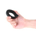 Hand holding a black silicone vibrating cock ring with a curved, ergonomic design and textured surface.