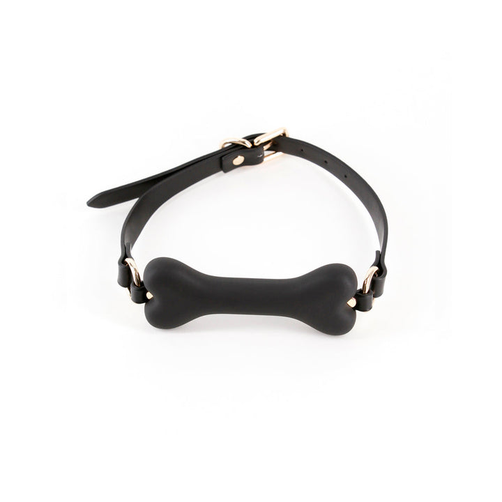 Black bone-shaped silicone gag with adjustable strap and gold-tone hardware on white background