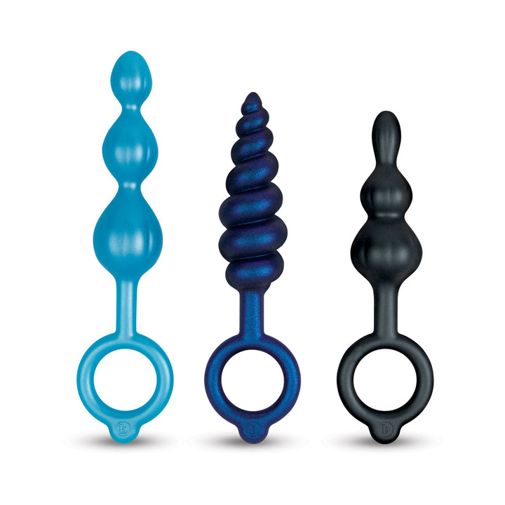 Set of three graduated silicone anal plugs in blue, metallic purple, and black with ring handles for easy grip.