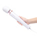 Hand holding Le Wand Plugin Sky White vibrating massager with long cord and control buttons visible