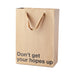 Brown kraft gift bag with brown ribbon handles and "Don't get your hopes up" printed in black text.