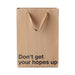 Brown kraft gift bag with brown ribbon handles and bold black text reading Don't get your hopes up.