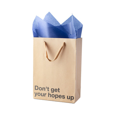 Kraft gift bag with brown ribbon handles and blue tissue paper, printed with "Don't get your hopes up" in bold text.