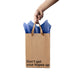 Hand holding a kraft gift bag with brown ribbon handles and blue tissue paper, printed with "Don't get your hopes up" text.