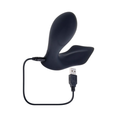 Black flexible silicone remote-control vibrator with USB charging cable attached on white background.