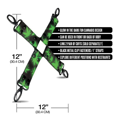 X-shaped black hogtie with green cannabis leaf pattern and black metal clips, 12-inch straps, glow-in-the-dark design.