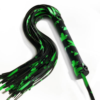 Glow-in-the-dark black and green faux leather flogger with multiple strands and a wrapped handle with wrist loop.