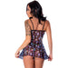 Back view of a woman wearing a sheer black mesh dress with colorful mushroom prints and adjustable straps, paired with a matching G-string.