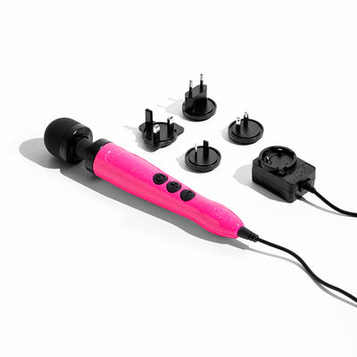 Doxy Die Cast 3 compact wand vibrator in glittery hot pink with multiple international plug adapters and power charger on white background.