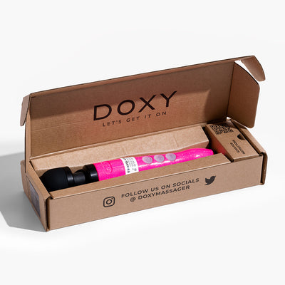 Doxy Die Cast 3R rechargeable compact wand vibrator in hot pink with glitter, displayed in open brown branded packaging.